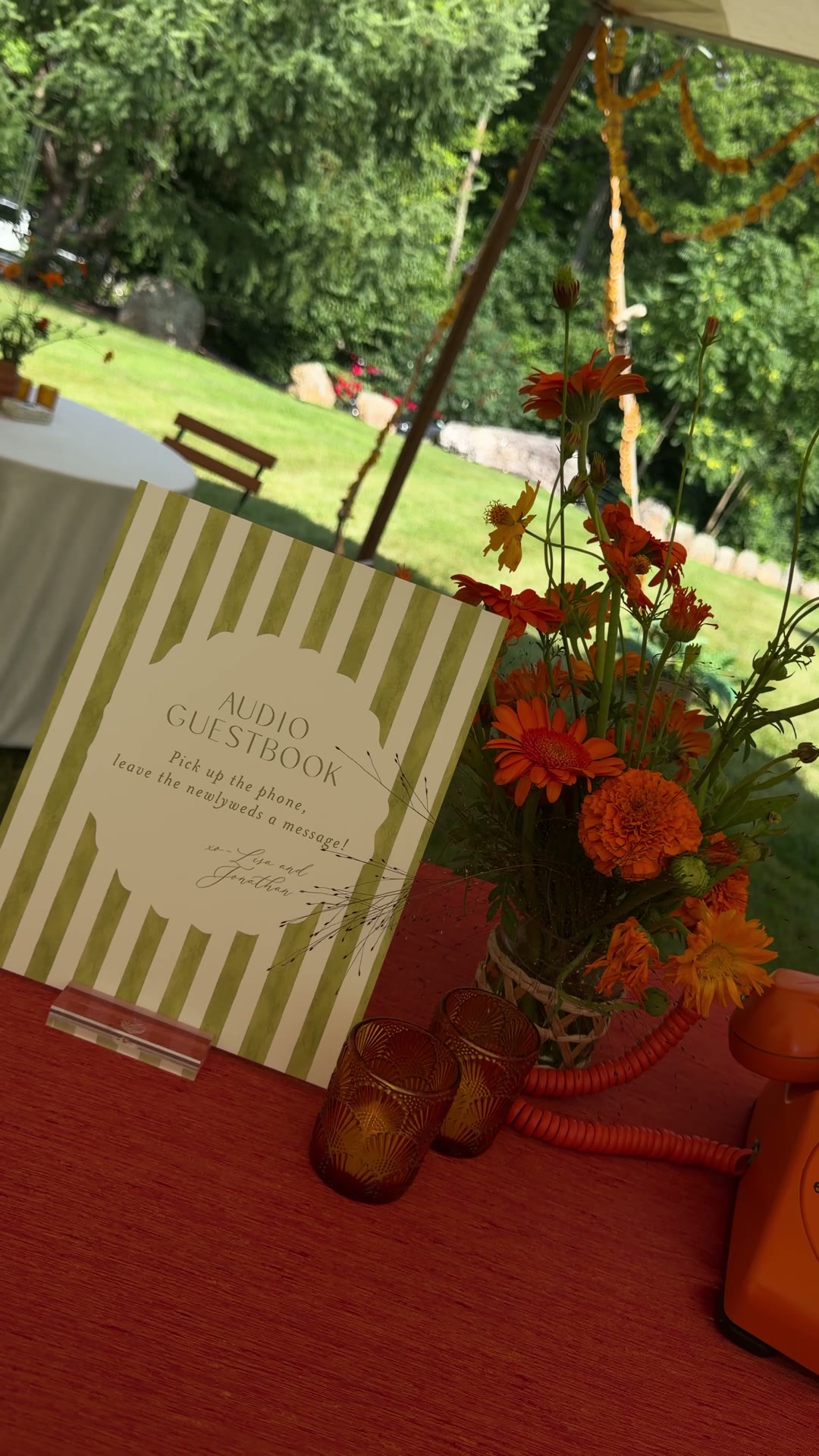 Close-up of the audio guestbook sign, flowers, and coiled phone cord at a wedding
